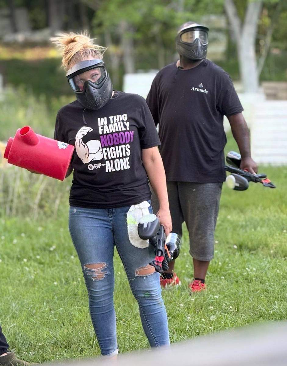Two people in paintball masks walking off the field, one in an Armada shirt